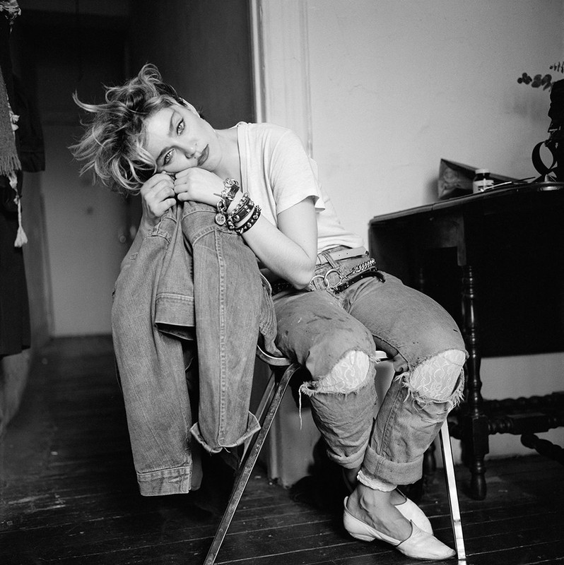 Madonna sits in a chair in her apartment in New York City