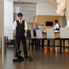 Female Cleaner Using Rubbermaid Lobby Pro Dust Pan to Tidy Outdoor Lobby Area