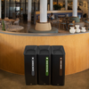 Three Rubbermaid Sustain Recycling Bins Placed Infront of a Bar