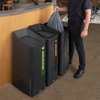 A Worked Removes a Bin Bag from One of Three Sustain Recycling Bins Placed Beside a Bar