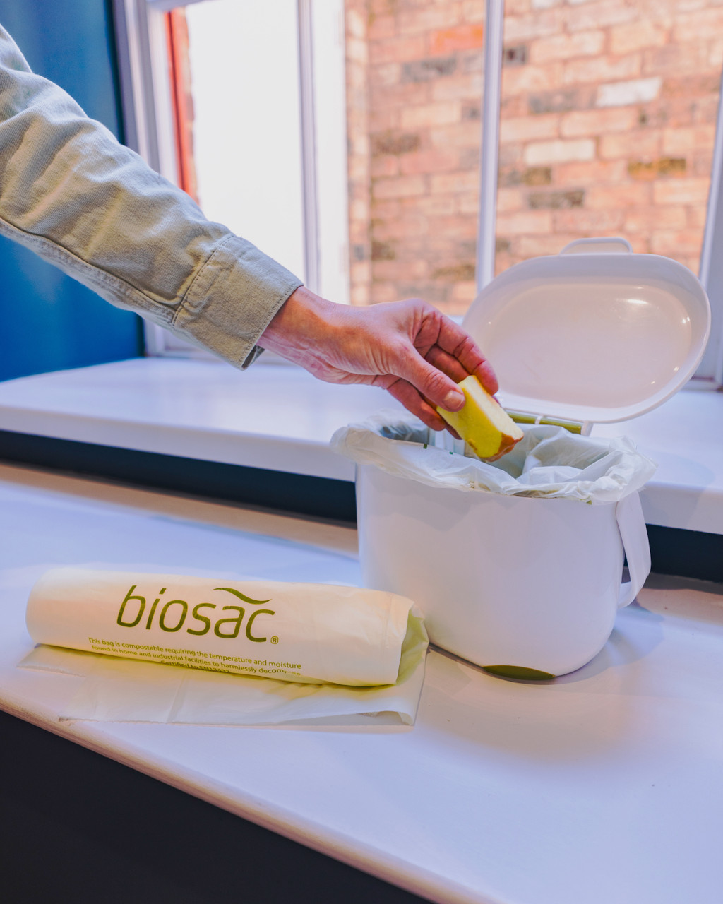 PMCBIO10 - Biosac Compostable Bin & Caddy Liner - 10 Ltr - Apple Core Being Placed in Caddy Lined with Biosac