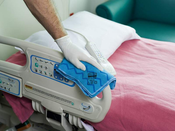 FGQ62000BL00 - Hospital worker wiping down the rails of a hospital bed with the HYGEN microfibre cloth FGQ62000BL00 - Hospital worker wiping down the rails of a hospital bed with the HYGEN microfibre cloth