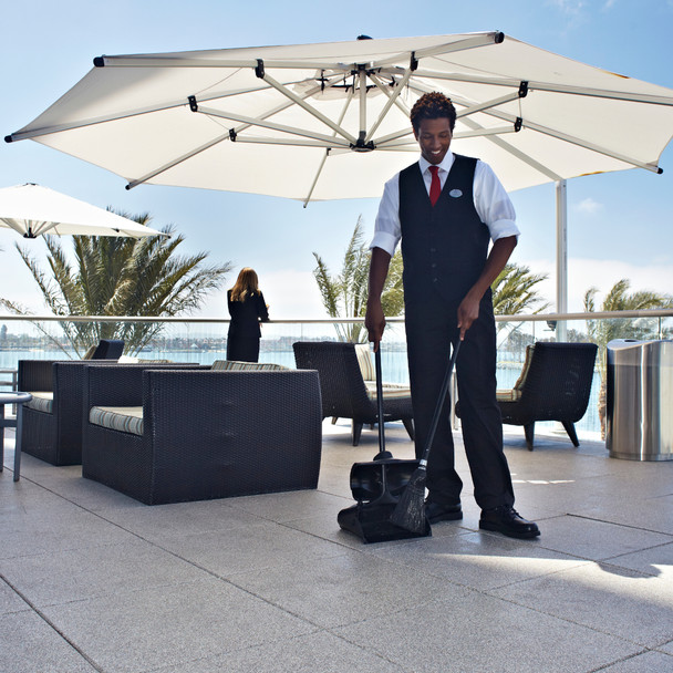 Male Cleaner Using Rubbermaid Lobby Pro Dust Pan to Tidy Outdoor Dining Area
