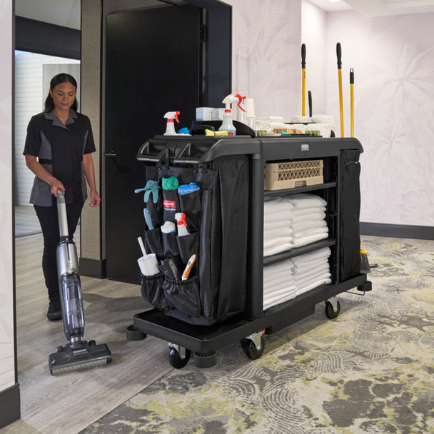 Cleaner Hoovering Hotel Corridor Next to housekeeping Cart with Rubbermaid 9-Pocket Organiser Attached