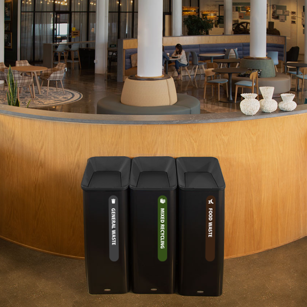 Three Rubbermaid Sustain Recycling Bins Placed Infront of a Bar