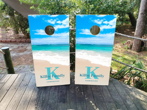 "Two cornhole board wraps featuring a bright beach scene with turquoise ocean waves, a sandy shore, a clear blue sky with white clouds, and personalized text reading 'Kilby Family' and 'Summer Fun' on the sand." "Two cornhole board wraps featuring a bright beach scene with turquoise ocean waves, a sandy shore, a clear blue sky with white clouds, and personalized text reading 'Kilby Family' and 'Summer Fun' on the sand."