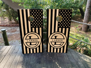 "Custom patriotic cornhole boards featuring a black and natural wood American flag design with a personalized monogram and last name. Perfect for military families, veterans, and patriotic celebrations." "Custom patriotic cornhole boards featuring a black and natural wood American flag design with a personalized monogram and last name. Perfect for military families, veterans, and patriotic celebrations."