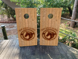 "Custom rustic cornhole boards featuring a natural wood plank background with a burned-in ranch-style logo design. Perfect for farmhouses, country weddings, and Western-themed events "Custom rustic cornhole boards featuring a natural wood plank background with a burned-in ranch-style logo design. Perfect for farmhouses, country weddings, and Western-themed events