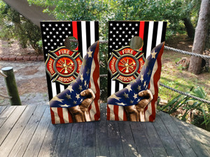 These cornhole wraps feature a bold firefighter theme. The background includes black and white stripes with a single red stripe, symbolizing the thin red line for firefighters. At the center, a prominent firefighter emblem displays the words "Courage, Honor, Rescue" surrounding fire-related symbols. A raised fist, wrapped in the American flag, represents strength and patriotism, with the stars and stripes flowing across the design. The overall look is patriotic and powerful, celebrating firefighters' bravery and dedication while evoking American pride.