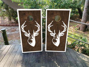 These cornhole wraps feature a simple yet striking design with a woodgrain background and a white silhouette of a deer's head with large antlers in the center. The rustic wood texture combined with the clean white outline creates a natural, outdoorsy feel, perfect for hunting enthusiasts or those who appreciate wildlife. The minimalistic design is framed by a white border, enhancing the contrast and giving the wraps a polished, stylish appearance. Ideal for outdoor gatherings or nature-themed events. These cornhole wraps feature a simple yet striking design with a woodgrain background and a white silhouette of a deer's head with large antlers in the center. The rustic wood texture combined with the clean white outline creates a natural, outdoorsy feel, perfect for hunting enthusiasts or those who appreciate wildlife. The minimalistic design is framed by a white border, enhancing the contrast and giving the wraps a polished, stylish appearance. Ideal for outdoor gatherings or nature-themed events.