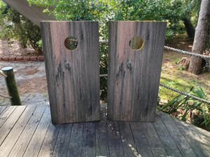 These cornhole wraps feature a dark, weathered gray wood grain design with vertical planks, creating a rugged and rustic appearance. Ideal for adding a vintage, natural look to cornhole boards for outdoor games. These cornhole wraps feature a dark, weathered gray wood grain design with vertical planks, creating a rugged and rustic appearance. Ideal for adding a vintage, natural look to cornhole boards for outdoor games.