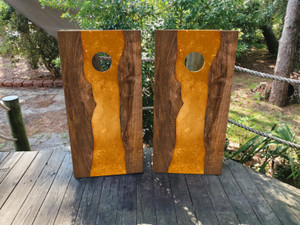 These cornhole wraps feature a striking design with dark wood grain on each side and a vibrant orange epoxy "river" flowing down the center. The combination of natural wood texture and bold epoxy color adds a modern, eye-catching element to any cornhole game. These cornhole wraps feature a striking design with dark wood grain on each side and a vibrant orange epoxy "river" flowing down the center. The combination of natural wood texture and bold epoxy color adds a modern, eye-catching element to any cornhole game.