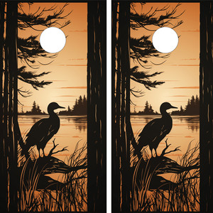 "Two cornhole board wraps featuring a silhouetted duck perched on a branch against a serene sunset over a lake, surrounded by tall grasses and trees, with a white scoring hole near the top of each board."