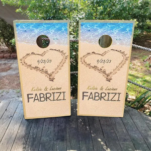 Custom beach wedding cornhole boards featuring a heart drawn in the sand with a personalized wedding date and names. Ocean waves and sandy shore design, perfect for destination weddings and coastal receptions. Custom beach wedding cornhole boards featuring a heart drawn in the sand with a personalized wedding date and names. Ocean waves and sandy shore design, perfect for destination weddings and coastal receptions.
