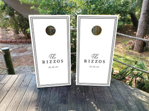 Modern white wedding cornhole board wraps featuring a minimalist black double-line border and elegant typography reading “The Rizzos – 10.26.25.” A clean, timeless design perfect for black-and-white weddings, modern receptions, or classic anniversary celebrations.