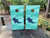 These cornhole wraps feature a marine theme with a blue, underwater-inspired design. The background consists of wavy, abstract water patterns in various shades of teal and aqua, creating a dynamic sense of movement. Each wrap prominently displays a dark blue whale shark silhouette, recognizable by its distinct white spots, swimming gracefully across the surface. The circular hole at the top is strategically placed above the shark, complementing the overall aesthetic. The design's vibrant colors and oceanic theme give the wraps a refreshing, aquatic feel, perfect for outdoor settings.