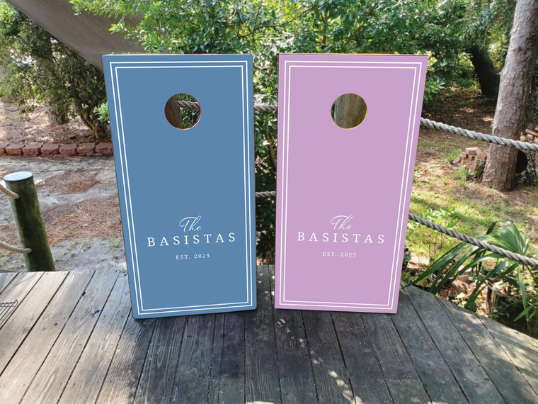 Pastel wedding cornhole board wraps in lavender and dusty blue, featuring minimalist double-line borders and elegant script that reads “The Basistas – Est. 2025.” A soft, modern design perfect for romantic outdoor weddings, spring celebrations, or garden receptions.