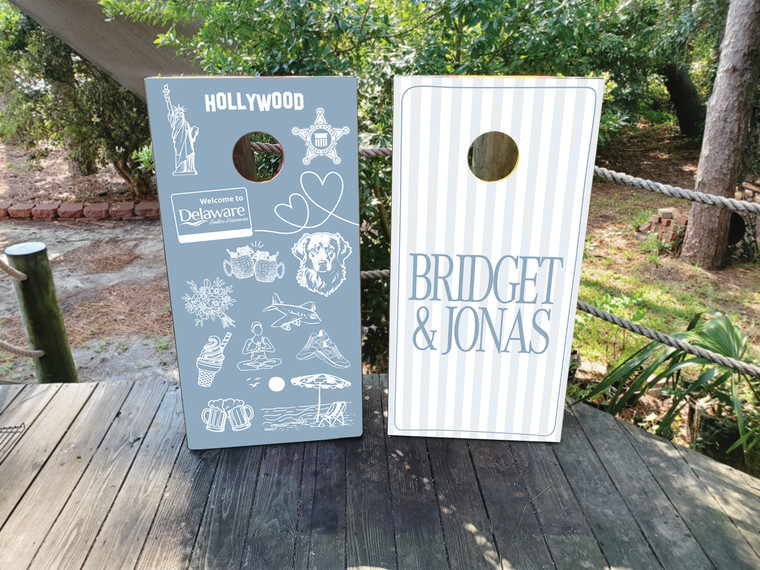 Custom cornhole design pairs a clean, modern striped monogram board with a custom illustrated collage board featuring meaningful symbols, places, and moments that represent your journey together.