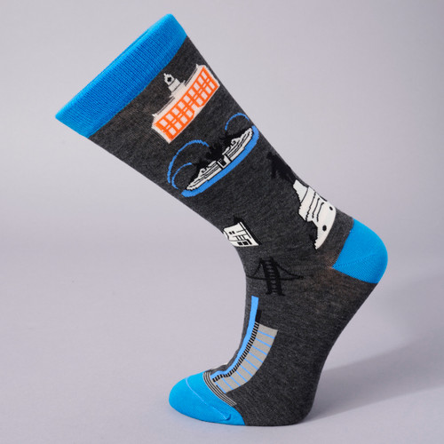 The Philadelphia Landmarks sock is shown in side view on a sock form. The body of the sock is dark grey, with blue toes, heels and top. Several Philadelphia landmark buildings are shown across the body of the sock in primarily whites, greys and blacks.