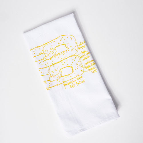 Aerial view of folded dishtowel featured a Philadelphia pretzel drawn with yellow lines.