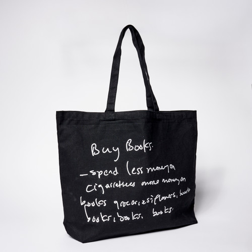 Black tote with artist Noah Davis' hand-written text- "Buy Books- spend less money on cigarettes more money on books groceries, flowers, books, books, books, books" printed in white on back
