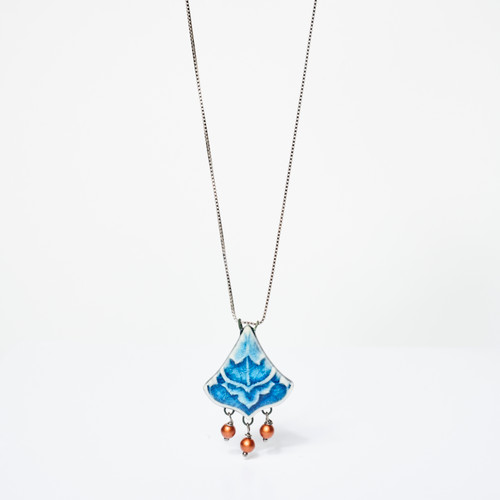 Blue triangular-shaped embossed ceramic pendant with 3 small beads dangling form the base hanging from a silver chain