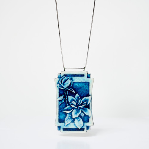 Rectangular blue ceramic pendant featuring embossed magnolia flowers on silver chain