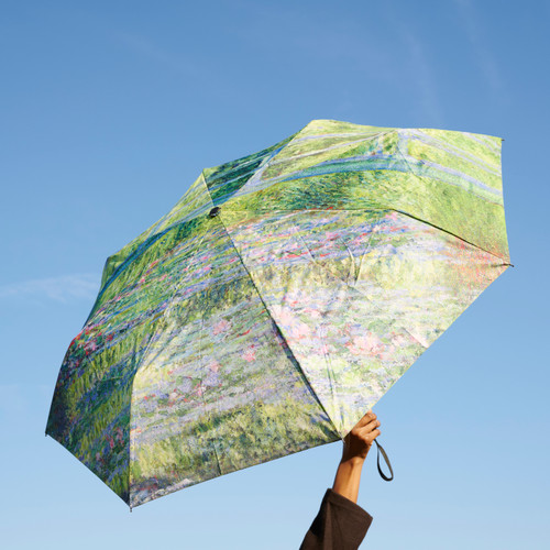 Monet footbridge umbrella shown open and with blue sky background