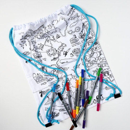 A white sling backpack with blue straps designed with a black outline of a world map and color-in illustrations of global landmarks and wildlife with a rainbow assortment of markers spread out at the bottom of the back.