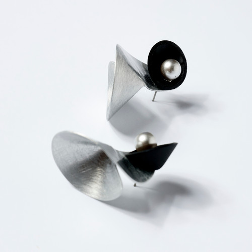 A pair of silver cone-shaped studs with black and silver accents.