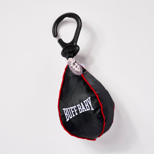 Front view of a small toy shaped like a black punching bag with red piping on a plastic clip that says "Buff Baby."