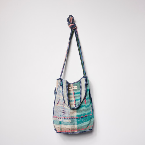 Front view of a colorful patchwork tote made of cool-toned fabrics.