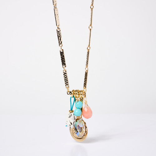 Front view of a gold chain link necklace with a pendant cluster of porcelain, turquoise, and shell gems.
