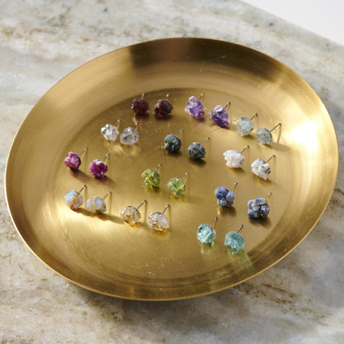 A gold catchall dish containing 12 pairs of birthstone gem stud earrings.