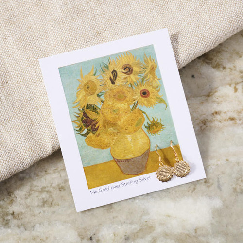 A small card featuring an image of a Sunflower painting by Vincent van Gogh and a small pair of gold sunflower dangle earrings attached to the card at the bottom right.