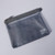 Front of grey Kleid Mesh Carry Pouch zip-top pouch with small printed text on lower right corner of pouch, shown laying flat on surface