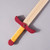 Up-close detail of the yellow & red wood handle and plain wood blade.