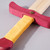 Up-close detail of the yellow & red wood handle.
