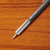 A partial view of the mechanical pencil shows the .7mm lead and the lower part of the barrel. The pencil lies on a wooden surface.