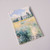 The front cover of this undated 52- week planner depicts Monet's Path on the Island of Saint Martin, Vetheuil.  The path is surrounded by tall grasses, a church is visible in the background behind a row of poplars; the main colors are shades of blues and greens.