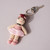 Wearing a tutu of primarily pink tones with brown hair Ballet Dancer Crocheted Keyring/Bag Charm shown flat with key ring with key attached to show scale and usage