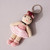 Ballet Dancer Crocheted Keyring/Bag Charm shown flat with key ring wearing a tutu of primarily pink tones with brown hair and pink ballet slippers