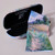 Monet's Path on the Island of Saint Martin, Vetheuil hardshell styrene-lined eyeglass case open, with folded microfiber cleaning cloth adjacent, front view.