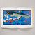 A spread of Japanese Woodblock Prints from the Basic Art series shows a woodblock print across both pages of a boat caught in a raging storm with a large fish emerging from the waves as one of the figures has been swept overboard.
