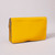 A yellow envelope wallet with blue contrast edging lies flat and partially open on a grey surface. Its snap closure and interior are visible.
