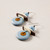 A pair of dangly earrings that feature a blue and brown circular design laid flat.