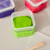 Image of one opened and 2 closed containers of dough out of the product packaging. Pink, green & purple dough are featured with a portion of the tool showing.
