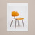 The front side of a postcard shows a photograph of a wooden chair with thin metal legs.