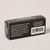 The reverse of a rectangular black cardboard box is shown with white text describing a handheld eraser made by Blackwing.