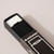 A white eraser in a black aluminum holder is nestled within a small black cardboard box with a white line illustration of the eraser on the front alongside Blackwing branding in white.